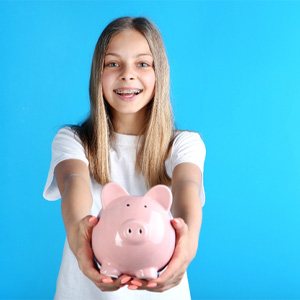 girl with braces and piggy bank for cost of traditional braces in Enfield 