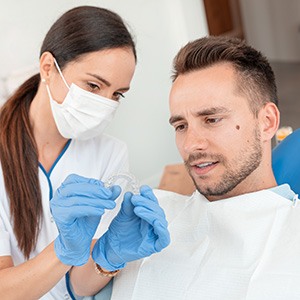 A Orthodontist showing her patient an Invisalign aligner