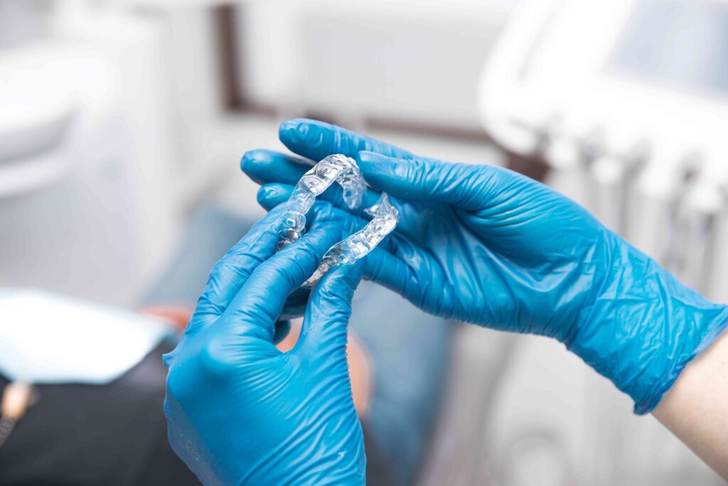 Dentist holding Invisalign aligners